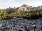 Crossing a boulder field below Peak 9963', with Glens Peak in the background.