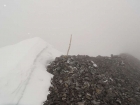 Summit marker in the fog.