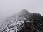 Climbers crossing the foggy ridge.