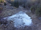 Frozen creek crossing the road.