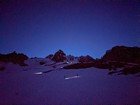 Surreal scene with climbers headlamps and stars.