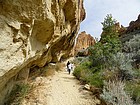 Hiking next to an overhanging rock face.