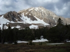 The morning sun shining on Whitecap Peak, with storm clouds building in the background.