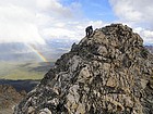 Sean nearing the summit of Anna's Pinnacle, rainbow below.