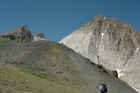 Arron taking a break on a mound above Castle Divide as Ken nears the saddle. Castle Peak behind them.